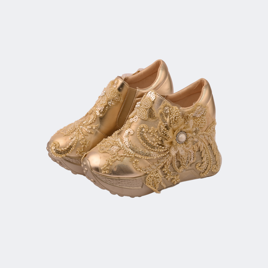 Gold children's shoes with floral embellishments on a light gray background | Vogelle