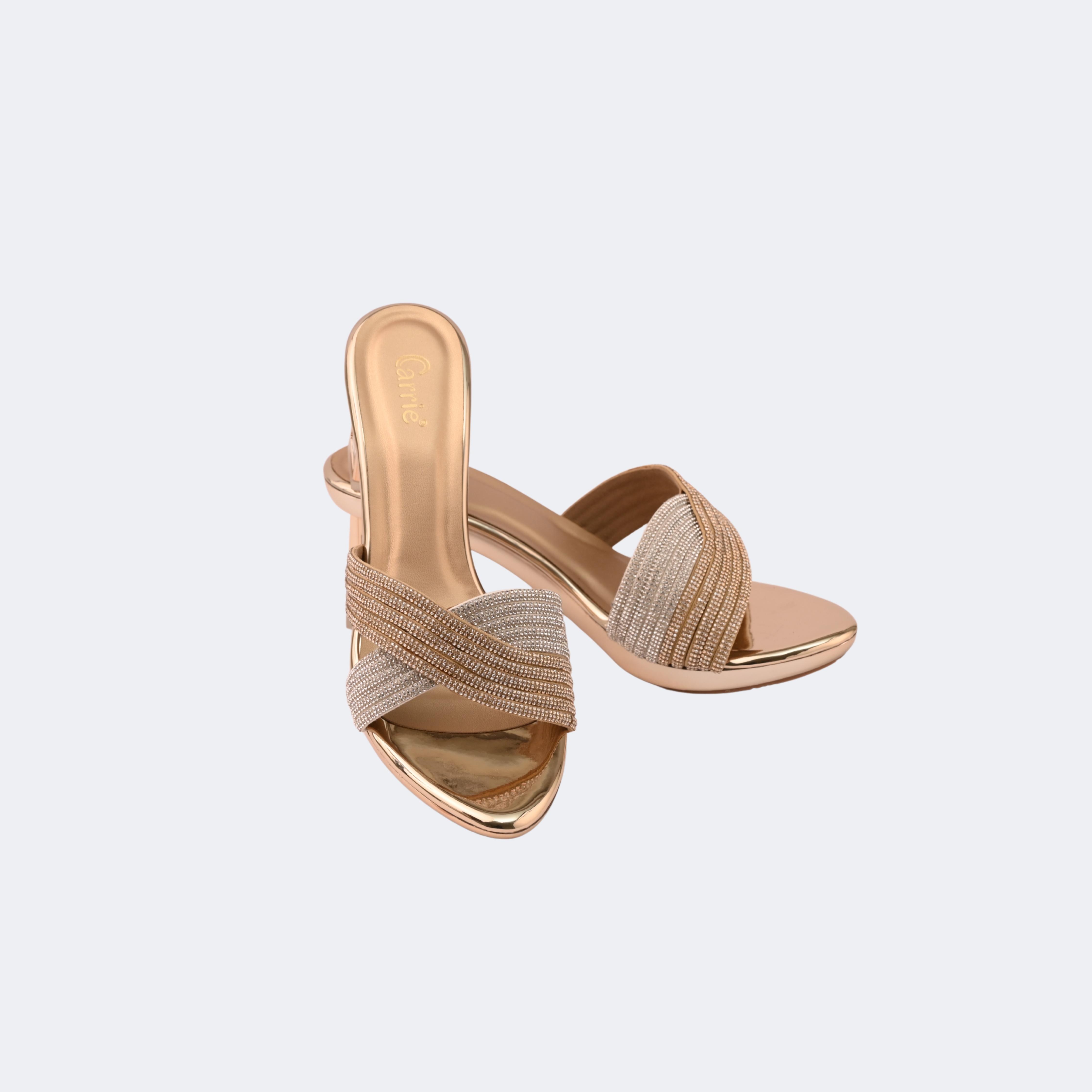 Pair of gold high-heeled sandals on a light gray background