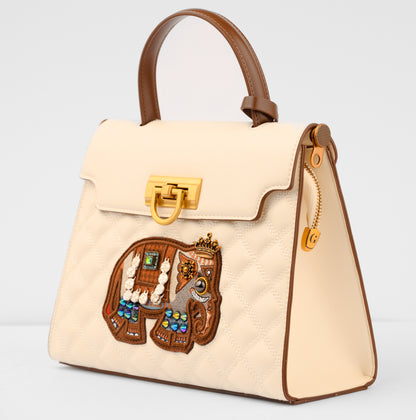 Beige handbag with decorative patch featuring animals and jewelry on a light gray background | Vogelle