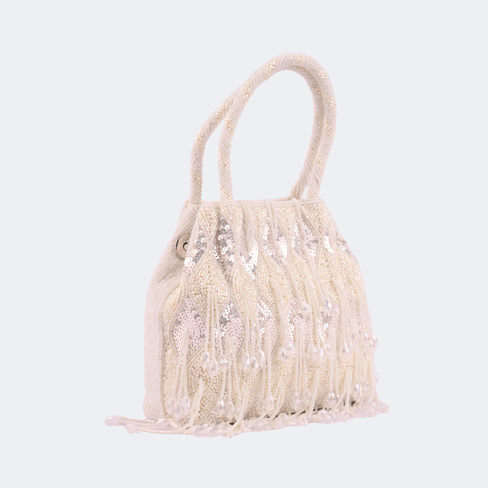 Beige handbag with fringe details on a light gray background | Vogelle