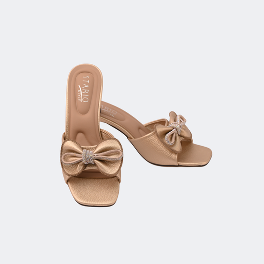 Beige high-heeled sandals with bow details on a light gray background | Vogelle