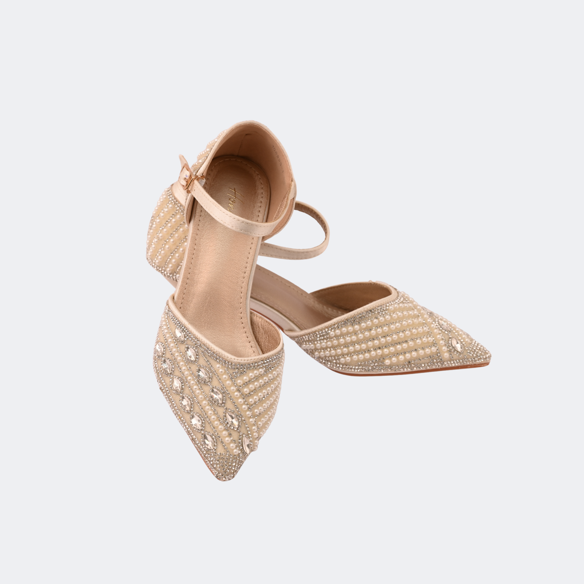 Beige pointed-toe shoes with embellishments on a light gray background | Vogelle