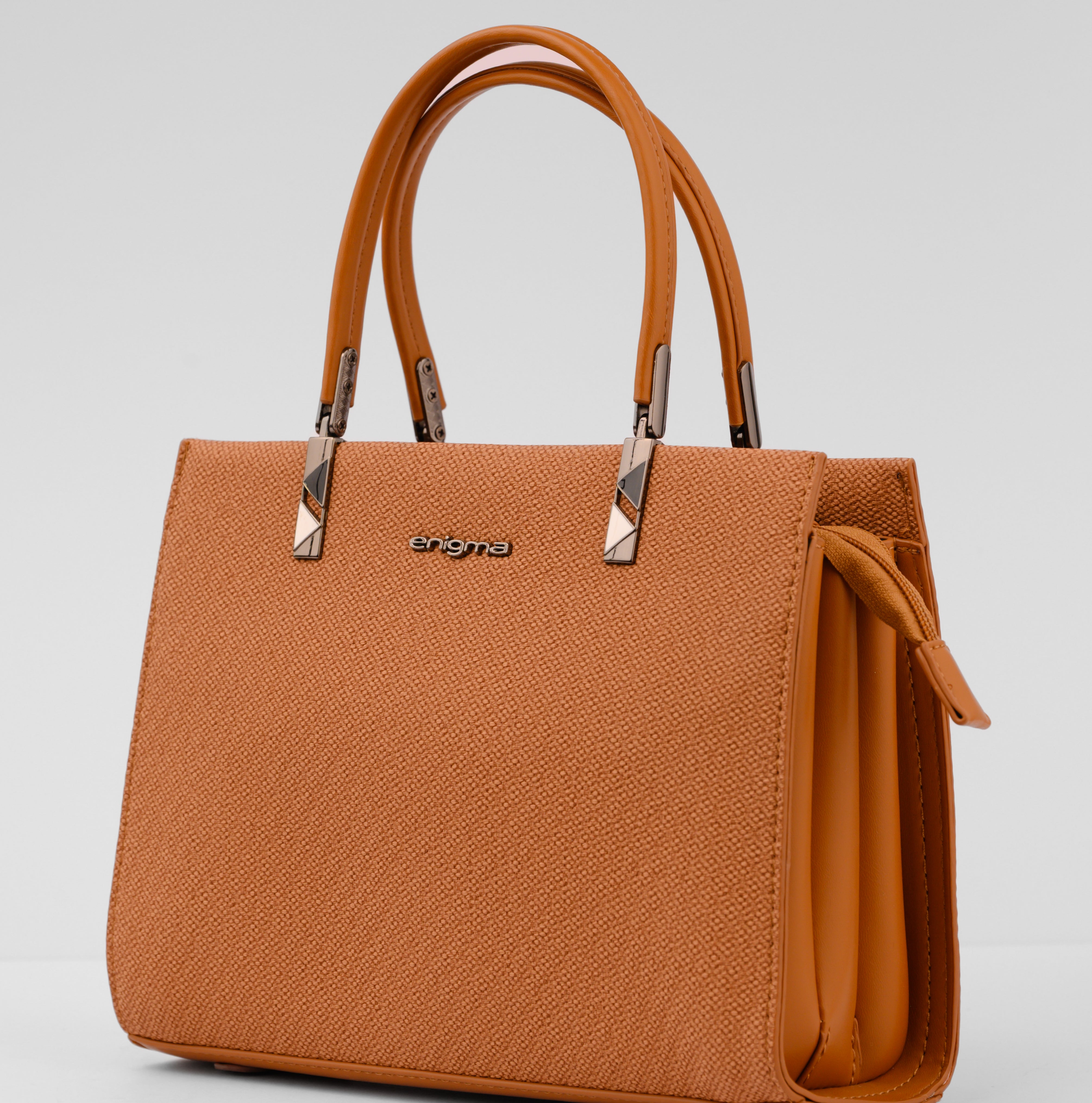 Brown handbag with a visible brand logo on a light gray background | Vogelle