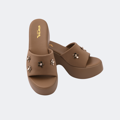 Brown sandals with floral embellishments on a light gray background | Vogelle