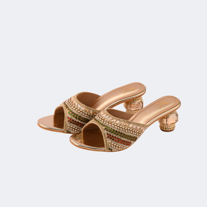 Gold embellished high-heeled sandals on a light gray background | Vogelle