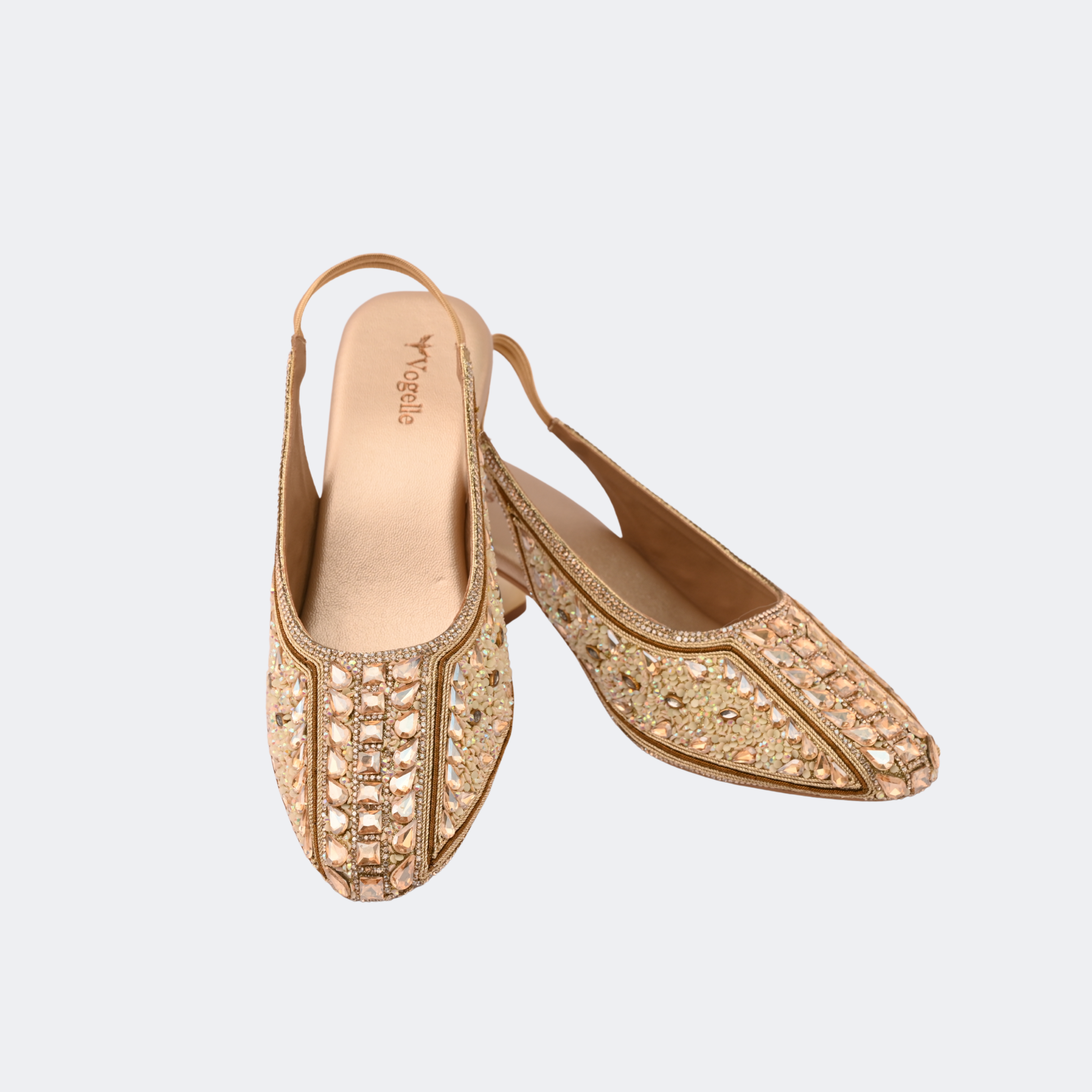 Gold embellished shoes on a light gray background | Vogelle