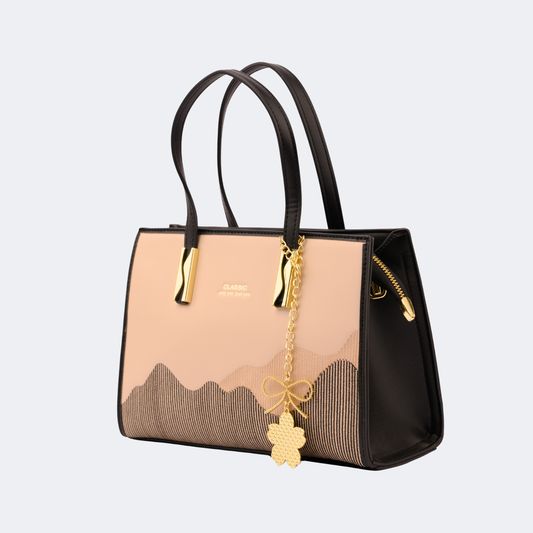 Handbag with gold chain and flower pendant on a light gray background | Vogelle
