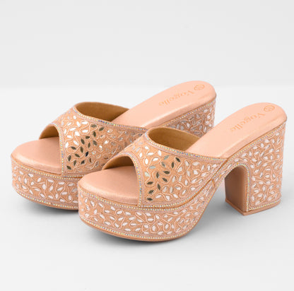 Pair of beige high-heeled sandals with intricate laser-cut design on a light gray background | Vogelle
