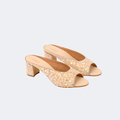 Pair of beige open-toe high-heeled shoes with embellishments on a light gray background | Vogelle