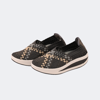 Pair of black and gray patterned slip-on shoes on a light gray background | Vogelle