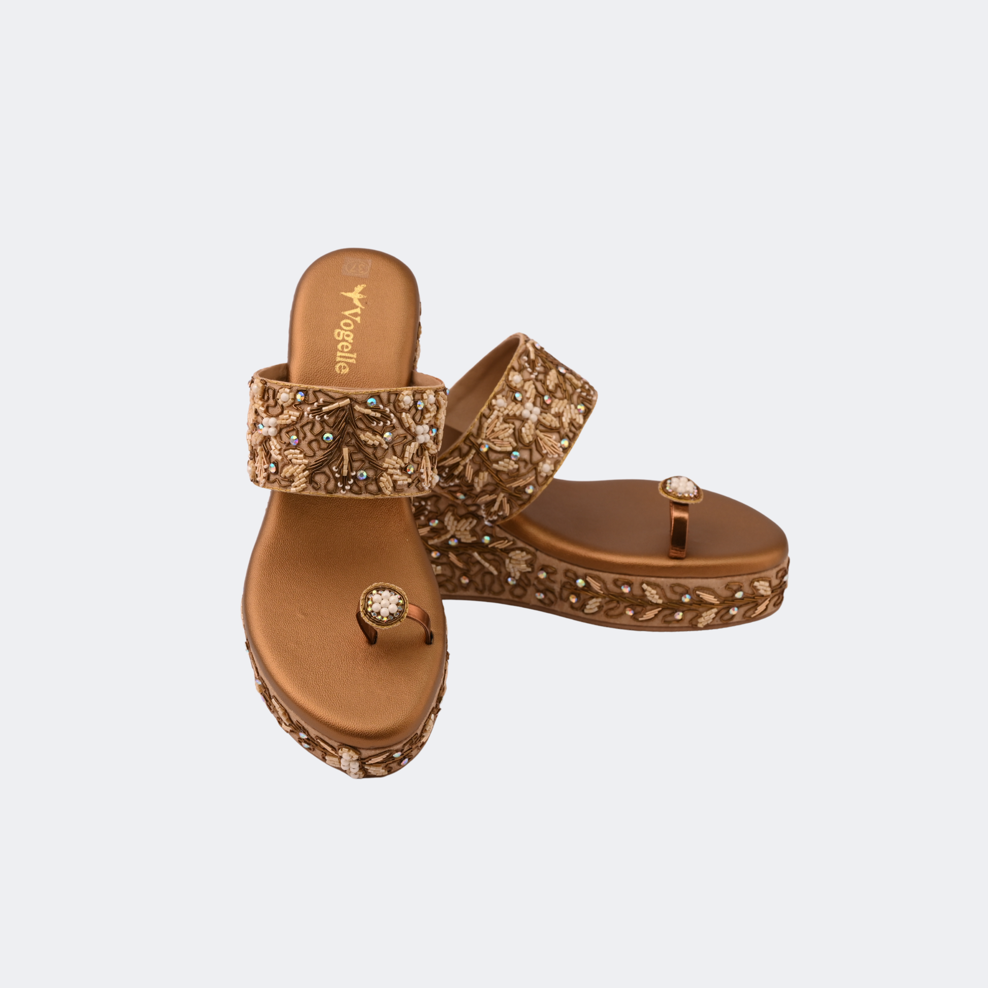 Pair of brown embellished sandals on a light gray background | Vogelle