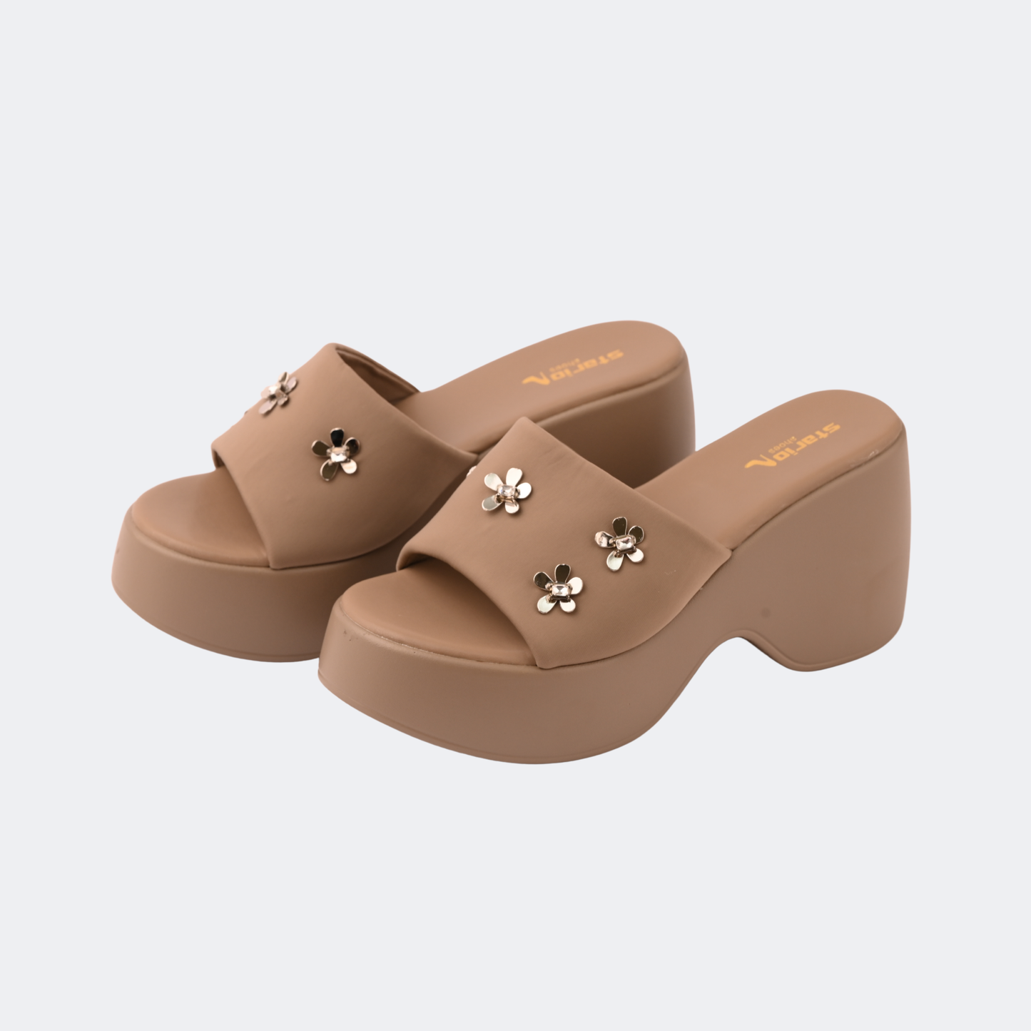 Pair of brown platform sandals with floral embellishments on a light gray background | Vogelle
