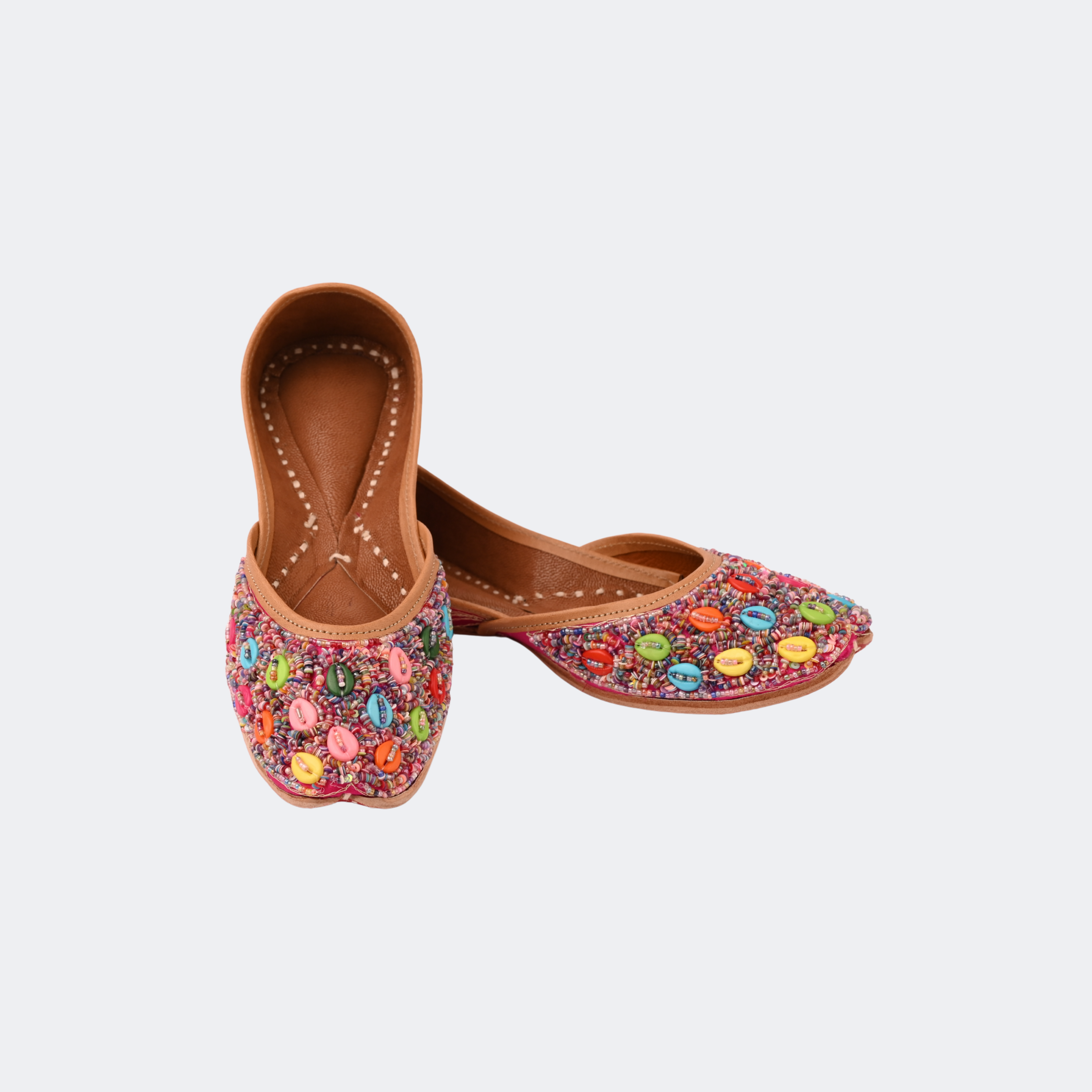 Pair of embellished shoes with colorful stones on a white background | Vogelle