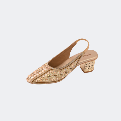 Pair of gold glittery high-heeled shoes on a light gray background | Vogelle