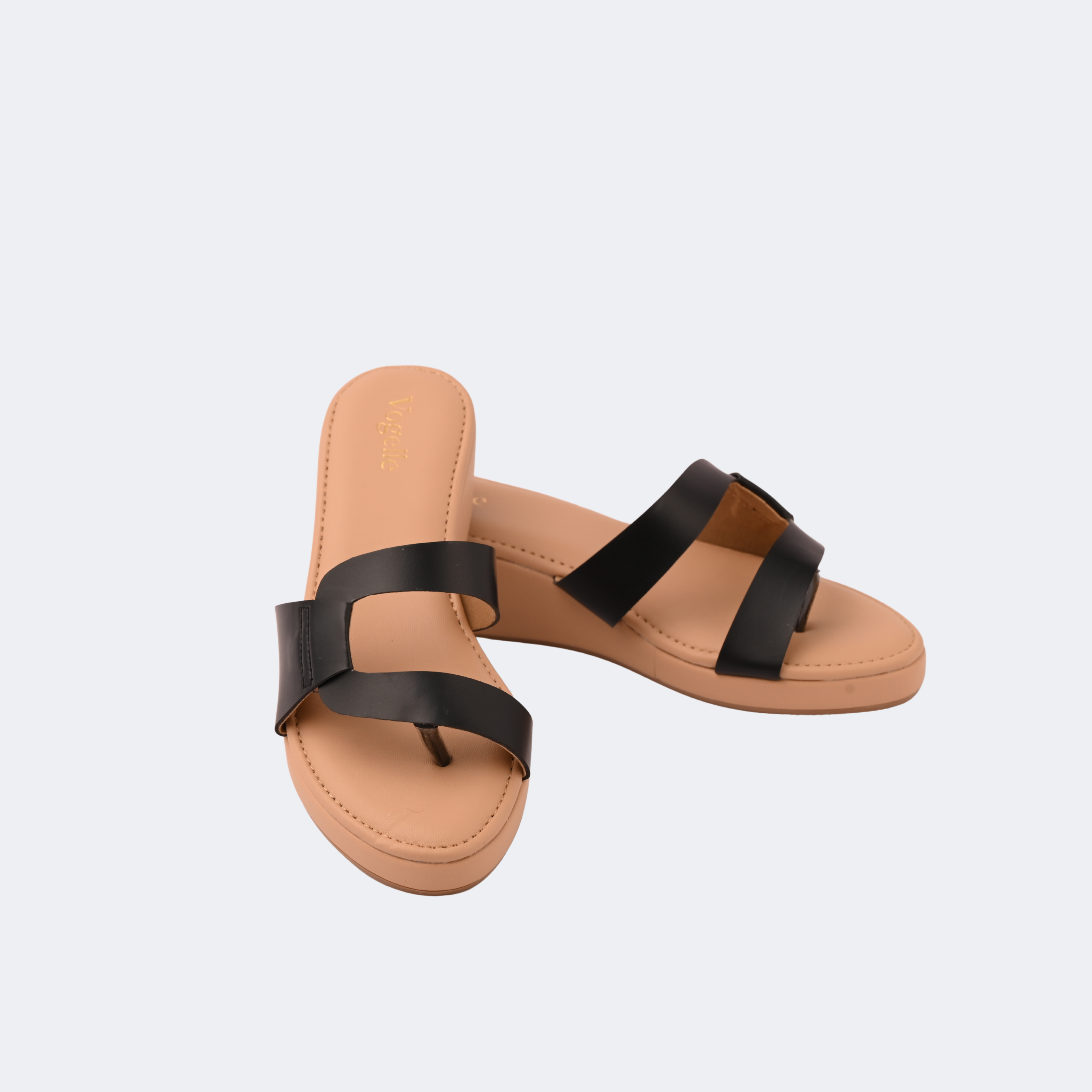 Pair of tan sandals with black straps on a light gray background | Vogelle