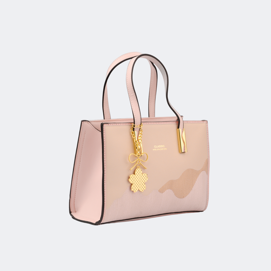 Pink handbag with a gold charm on a light gray background | Vogelle