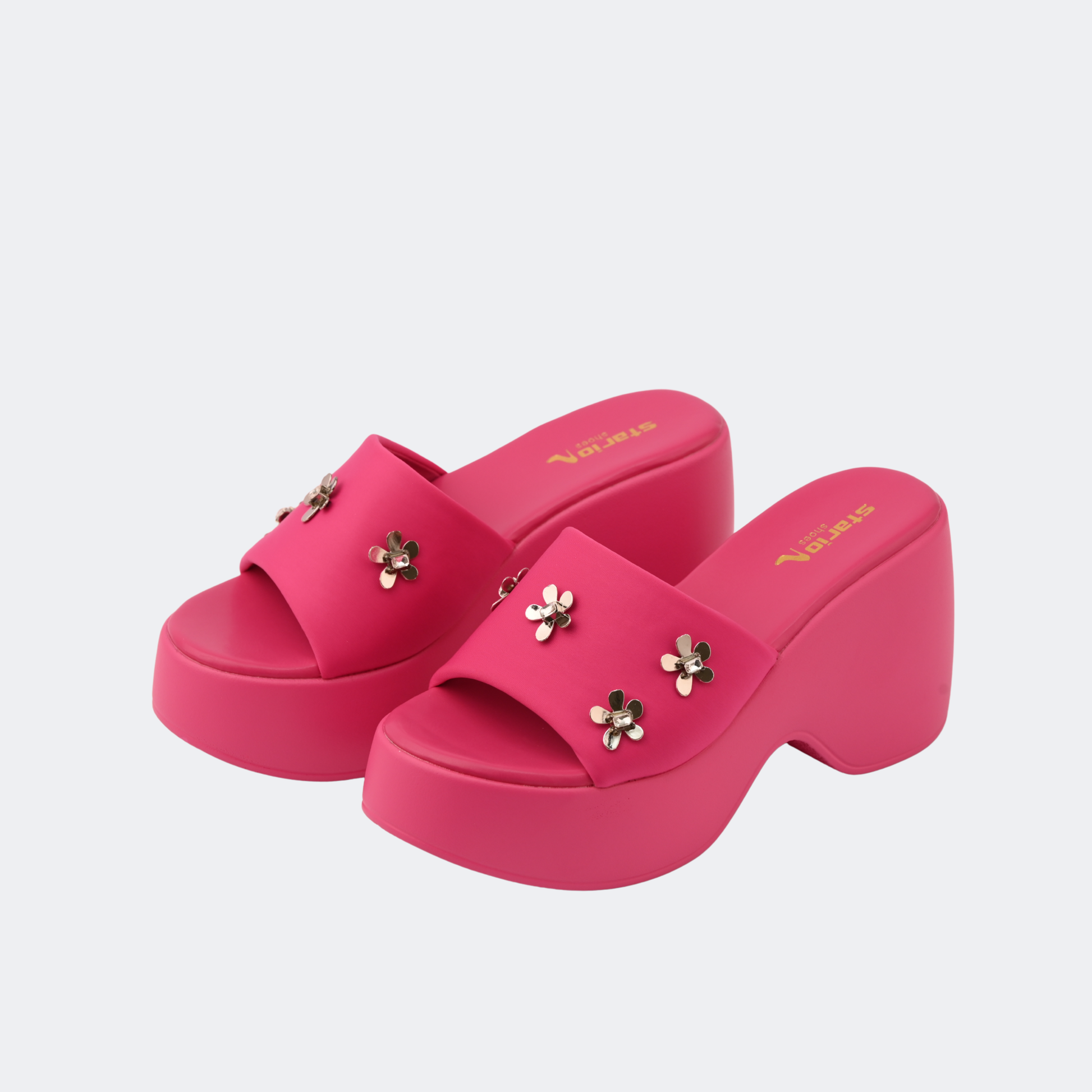 Pink platform sandals with floral embellishments on a light gray background | Vogelle