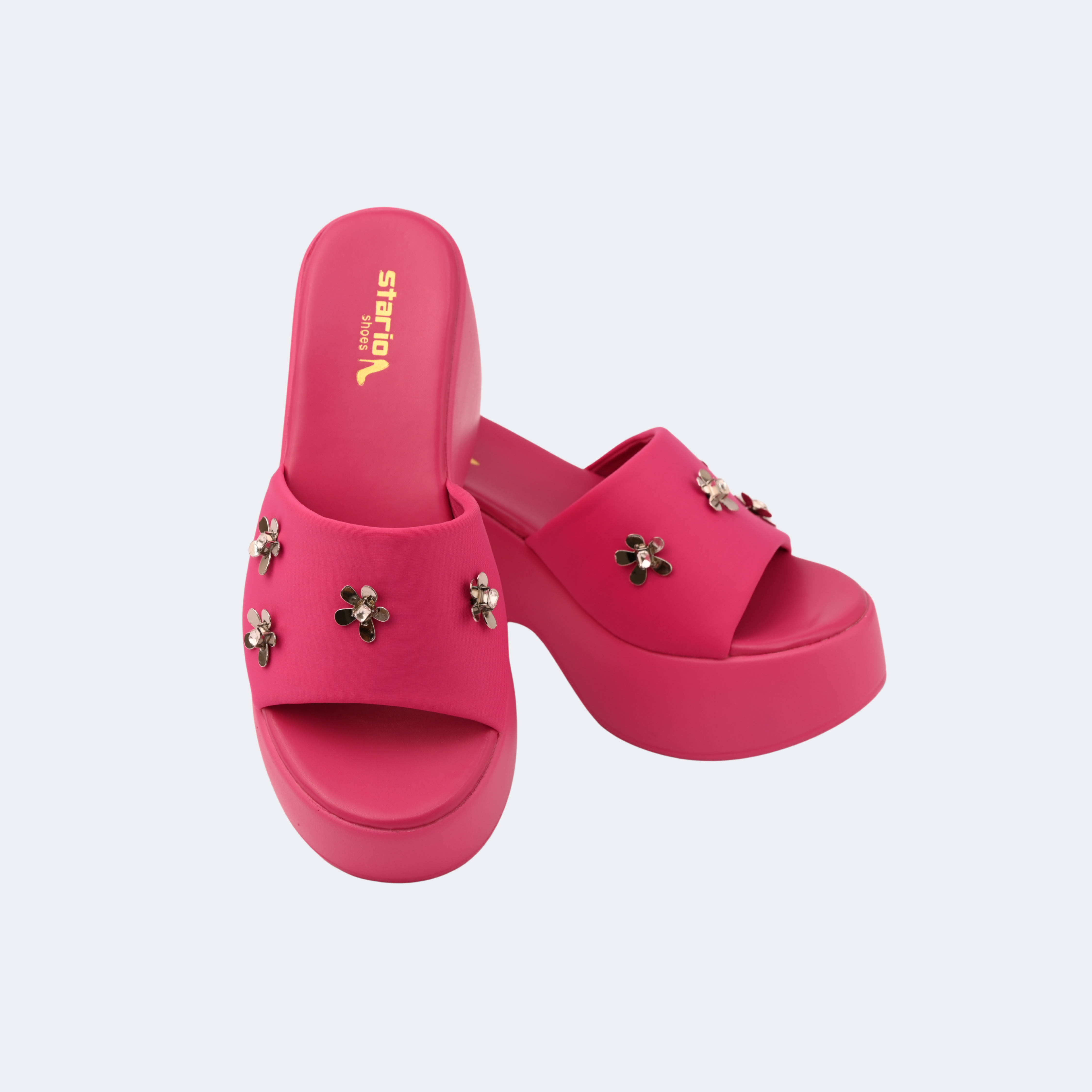 Pink platform sandals with floral embellishments on a light gray background | Vogelle