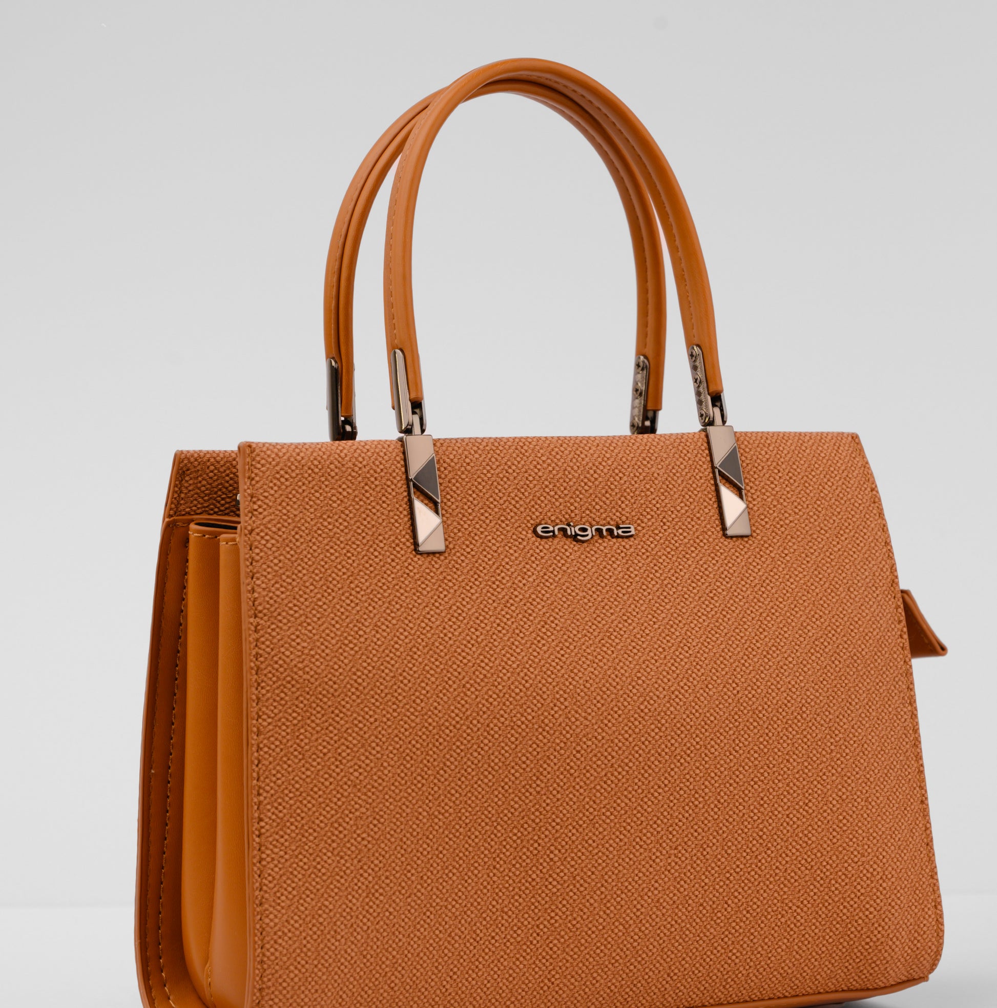 Brown handbag with a visible brand logo on a light gray background | Vogelle