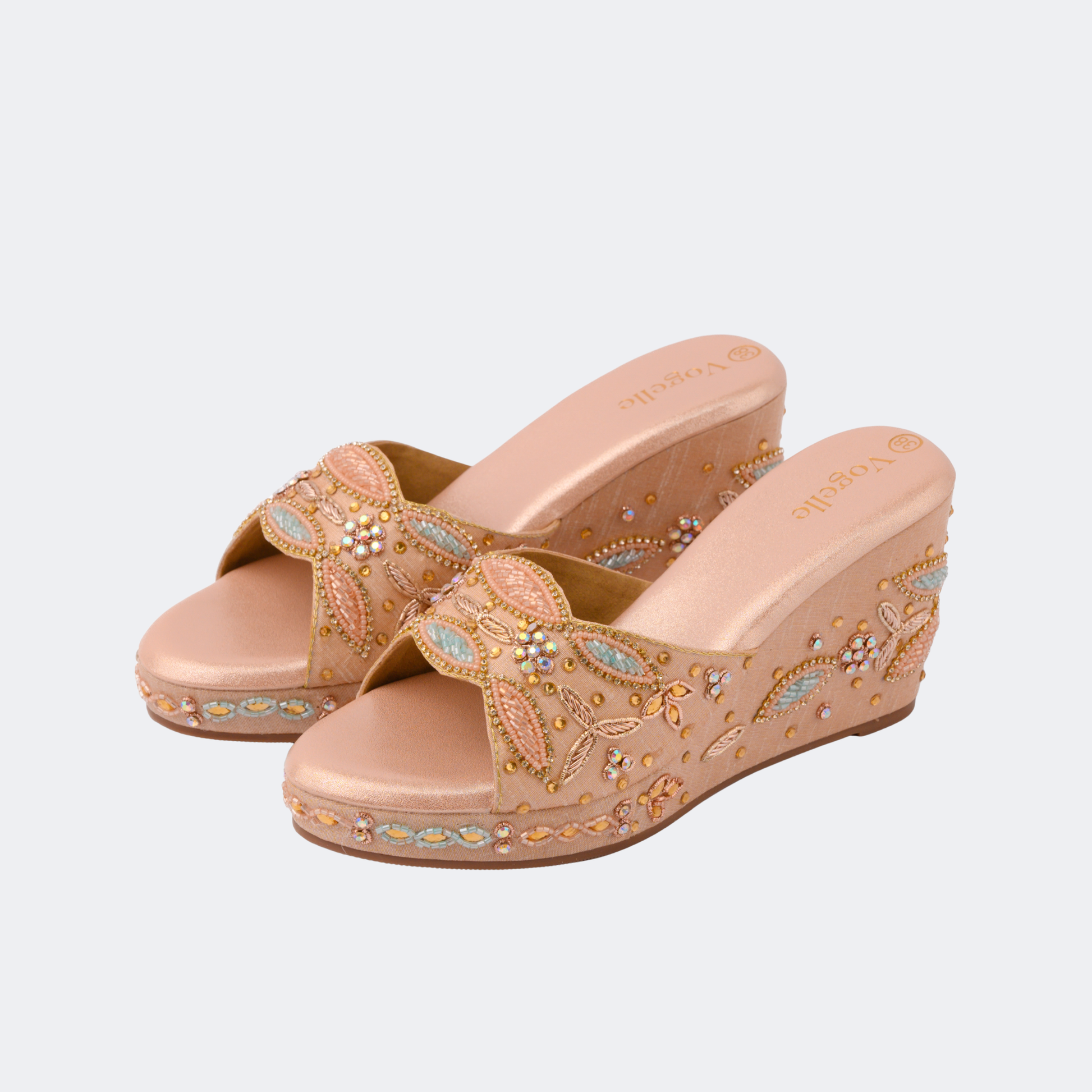 Pair of beige wedge sandals with decorative patterns on a light gray background | Vogelle