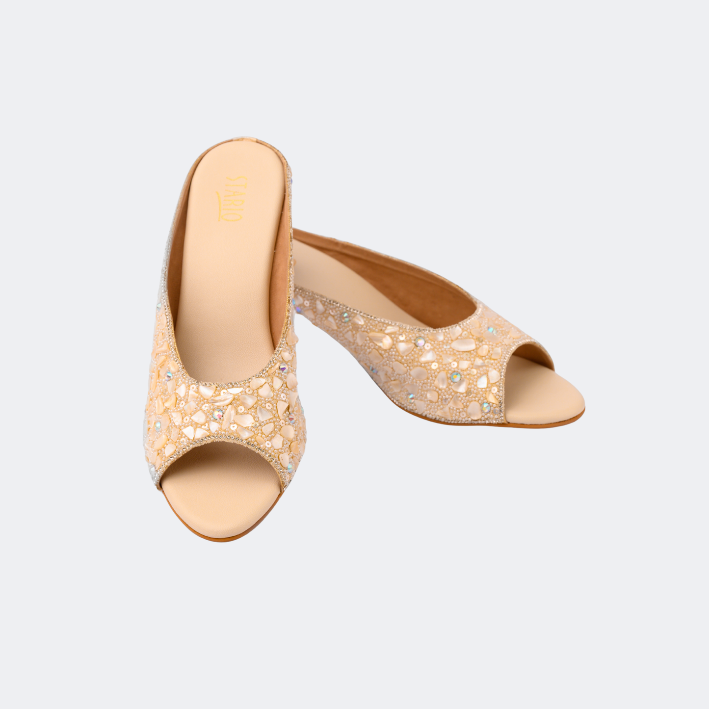Pair of beige open-toe high-heeled shoes with rhinestone embellishments on a light gray background | Vogelle