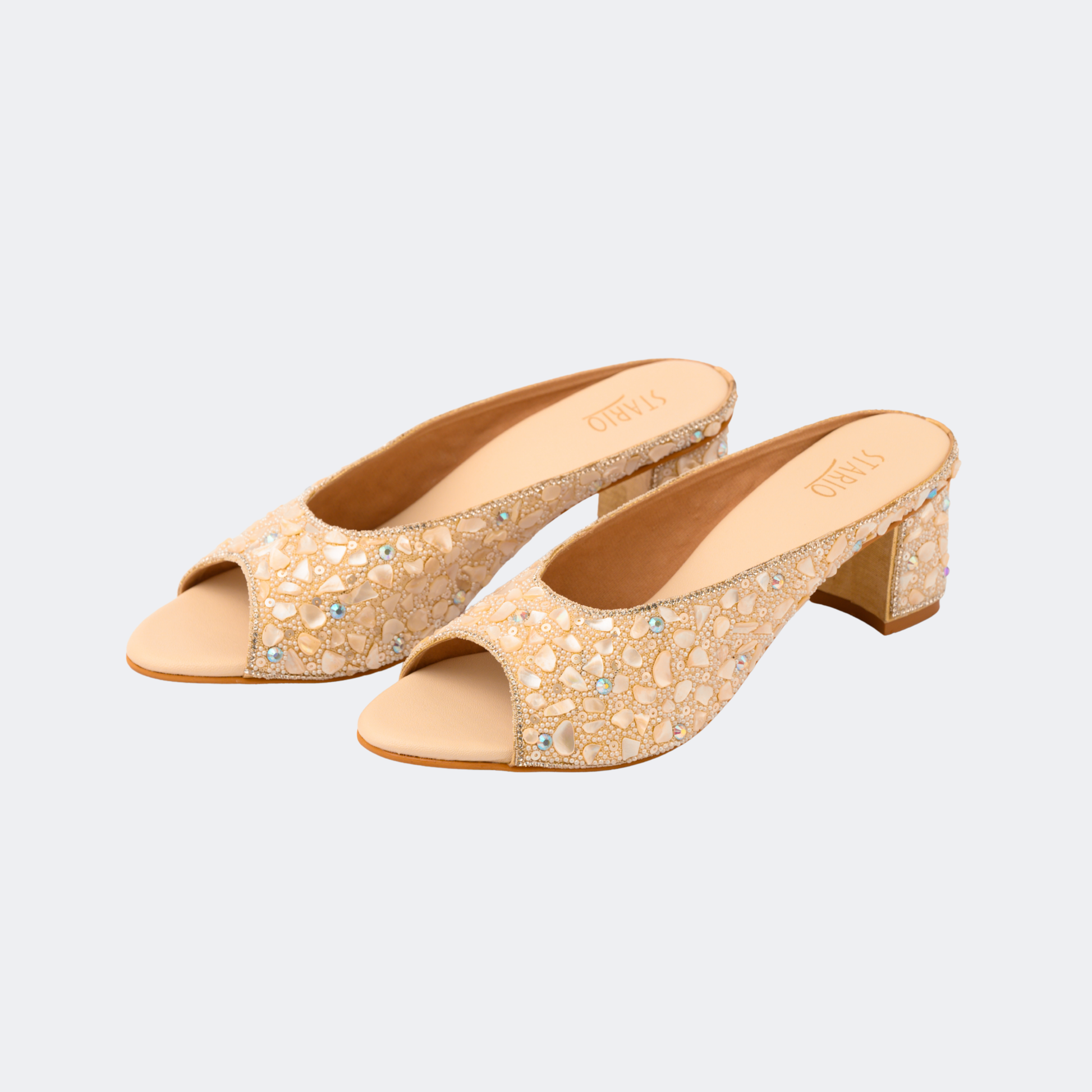 Pair of beige open-toe shoes with rhinestone embellishments on a light gray background | Vogelle
