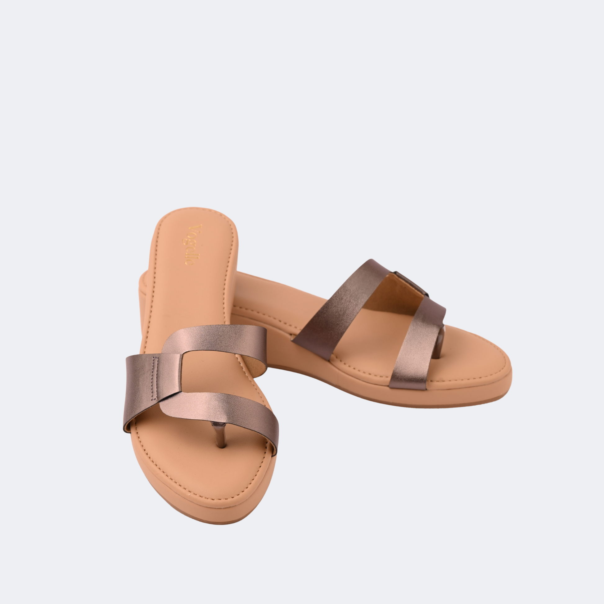 Pair of tan sandals with metallic straps on a light gray background | Vogelle